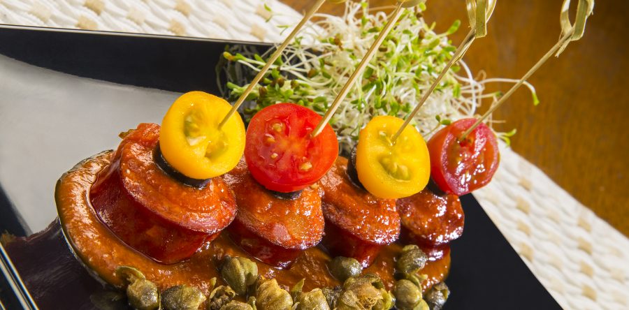 Espetinho de linguiça defumada ao molho putanesca